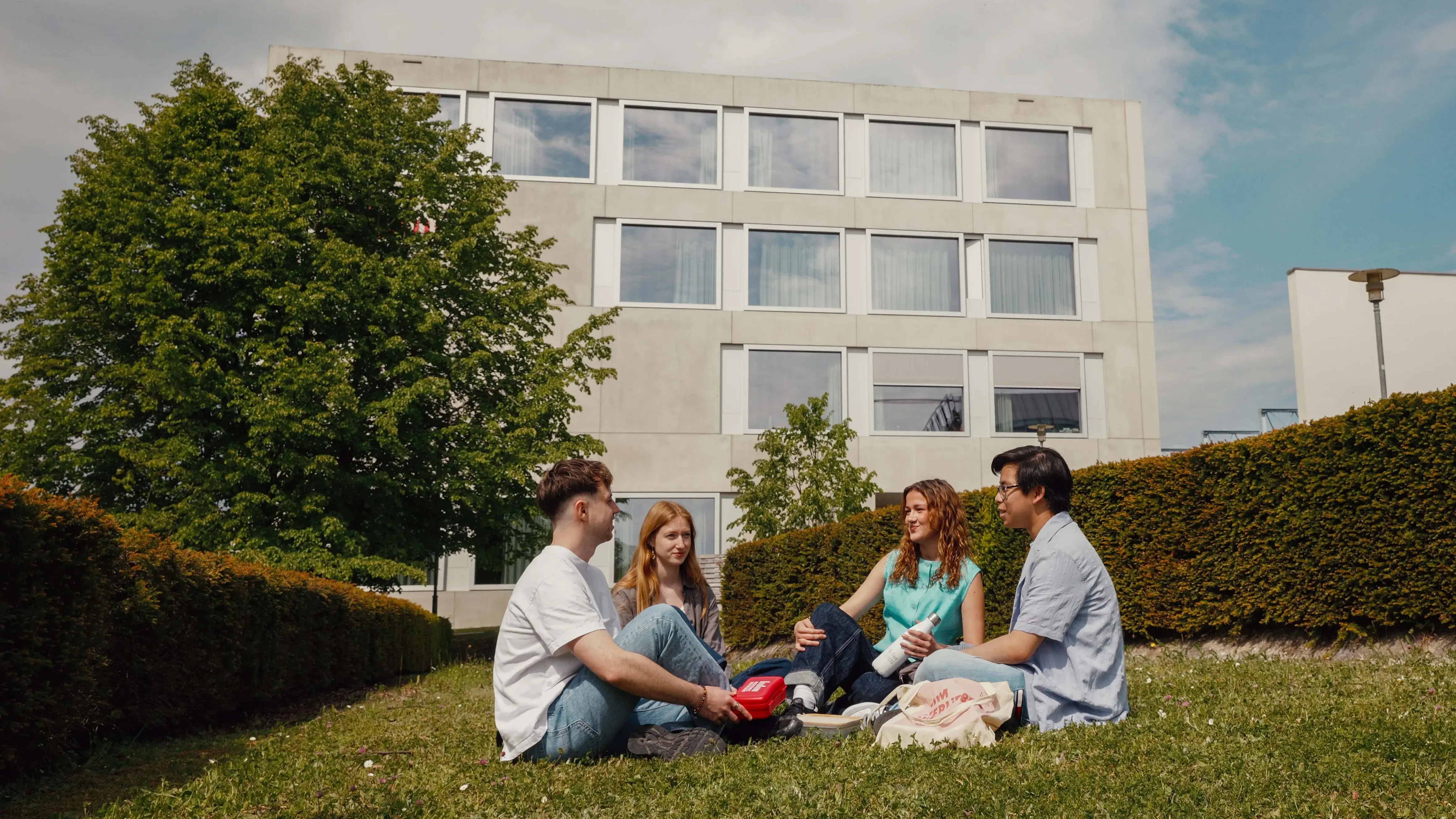 Students picnicking on the campus of the Hochschule der Medien.