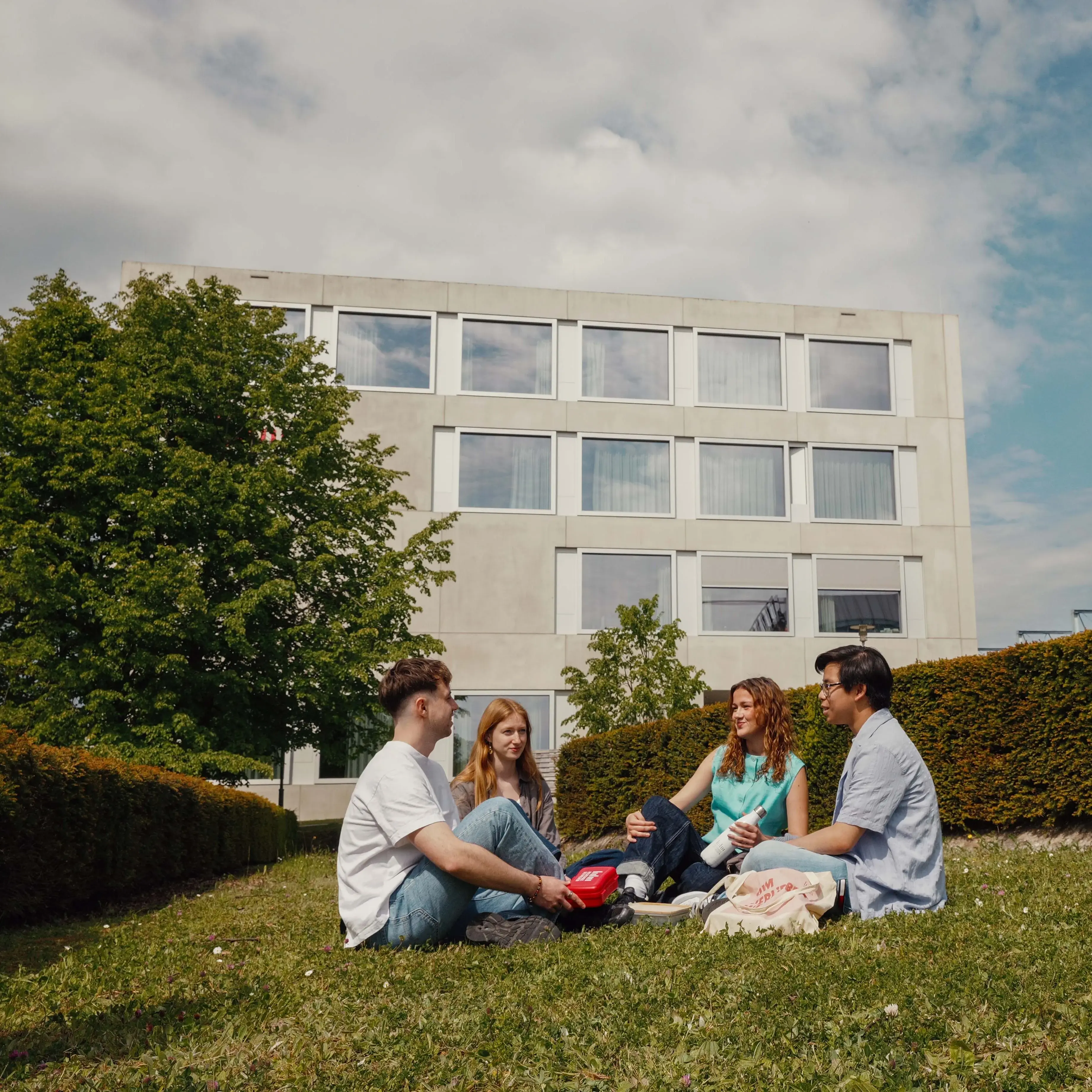 Students picnicking on the campus of the Hochschule der Medien.