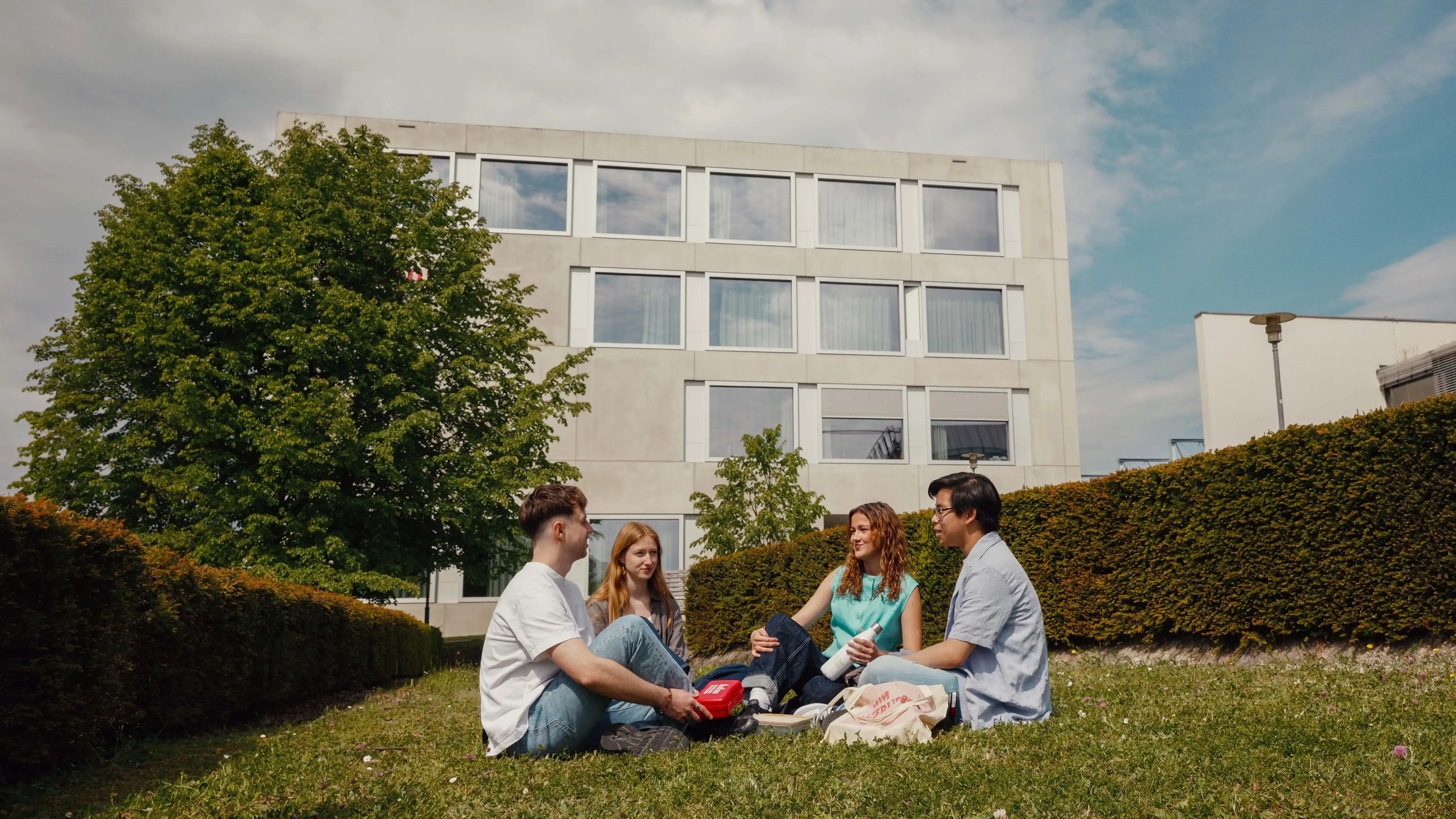Students picnicking on the campus of the Hochschule der Medien.